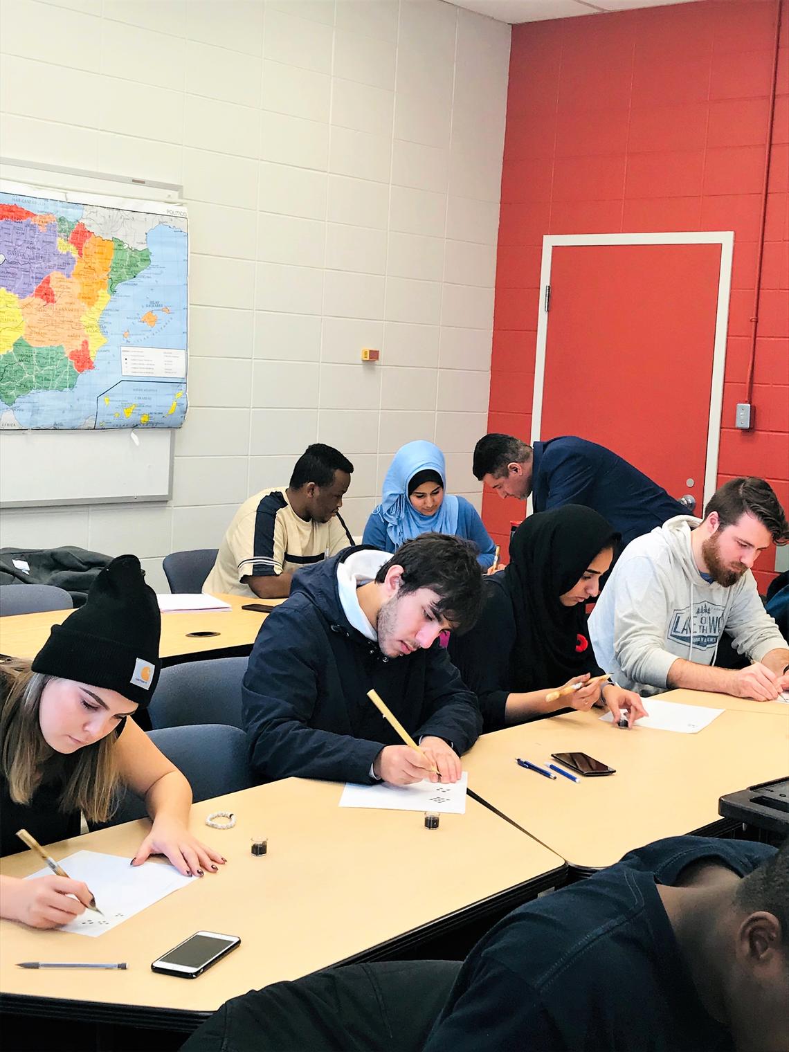 Students attend a two-hour calligraphy workshop held by Najm Al-Tameemi