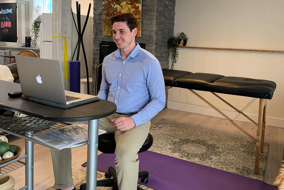 Brett Henderson, physiotherapist in the Sport Medicine Centre, videoconferences with a patient. 