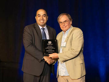 Mohamed Elhabiby accepts the award from Steve Larter