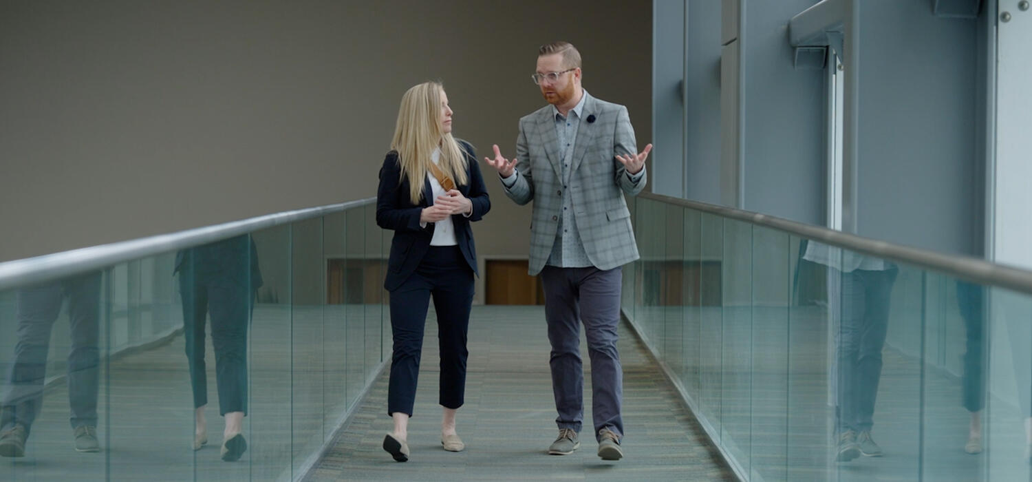 Two people walk towards the camera