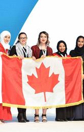 The UCalgary team accepts their silver award with a flag borrowed from the Canadian Embassy in Doha. From left: Hager Ben Mansour, Faculty of Science; Mais Abu Saleh, Faculty of Kinesiology; Rineem Saleh and Heyam Abdulrahman, Faculty of Arts; Machaille Al-Naimi, of the Qatar Foundation; Ziad Abusara, team coach from the Faculty of Kinesiology; and Hayat Abdullah Marafi, the executive director of QatarDebate. Photos courtesy Ziad Abusara